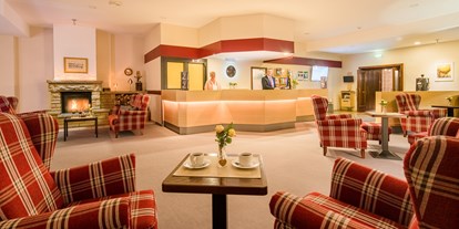 Essen-gehen - Hessen - Hotellobby mit Rezeption, gemütlichem Sitzbereich und Kamin - Restaurants "Libelle" & "blaue Ente" im Waldhotel Schäferberg