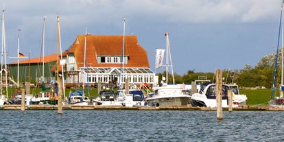 Essen-gehen - Deutschland - Das Restaurant "Kajüte am Hafen" Langeoog vom Wasser aus gesehen. - Kajüte am Hafen Langeoog